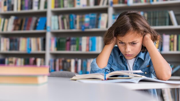 Niño de vista frontal pensando en cómo resolver su tarea con espacio de copia