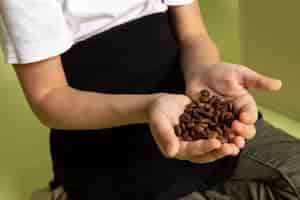 Foto gratuita un niño de vista frontal con semillas de café en camiseta blanca sobre el escritorio de color piedra