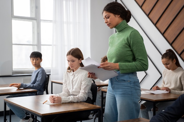 Foto gratuita niño de vista lateral haciendo trampa en el examen escolar