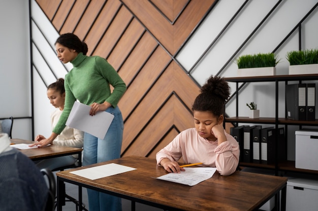 Foto gratuita niño de vista lateral haciendo trampa en el examen escolar