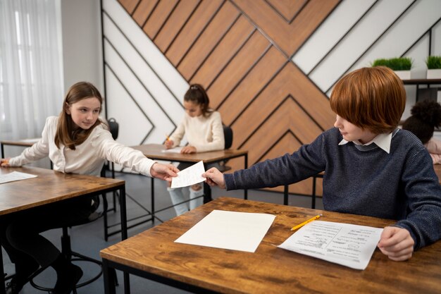 Foto gratuita niño de vista lateral haciendo trampa en el examen escolar