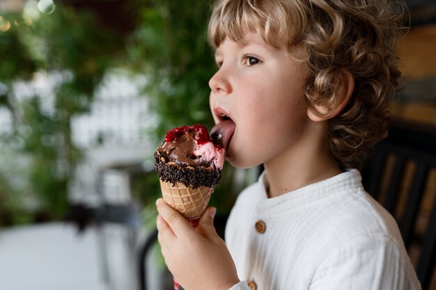 Niño de vista lateral lamiendo cono de helado