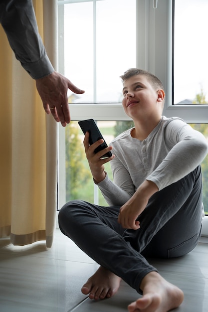 Niño de vista lateral con teléfono inteligente