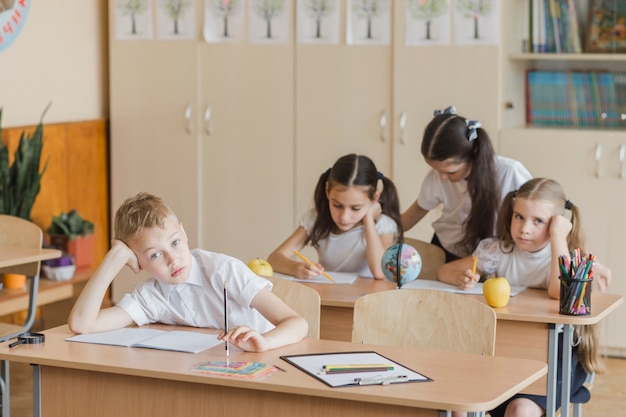 Niños aburridos sentados en el aula