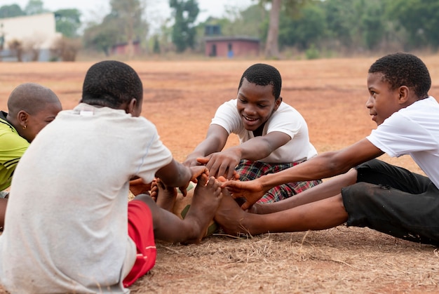 Niños africanos con pelota de fútbol sentado