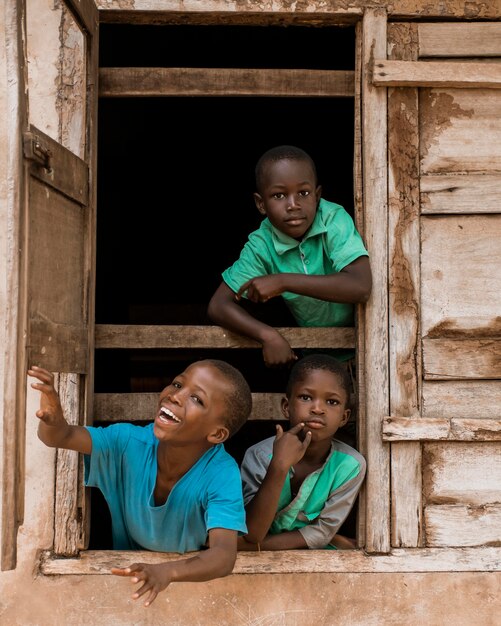 Niños africanos de tiro medio en la ventana