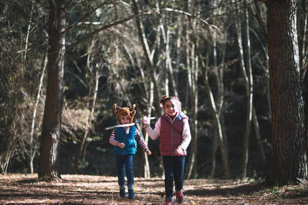 Niños alegres corriendo en el bosque