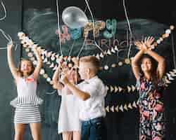 Foto gratuita niños alegres lanzar globos en la fiesta de cumpleaños
