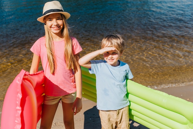 Foto gratuita niños alegres sonriendo en un día caluroso en la playa