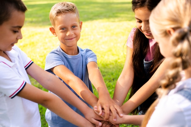 Niños alegres uniendo manos