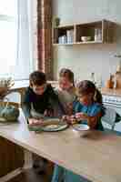 Foto gratuita niños de alto ángulo cocinando juntos en casa