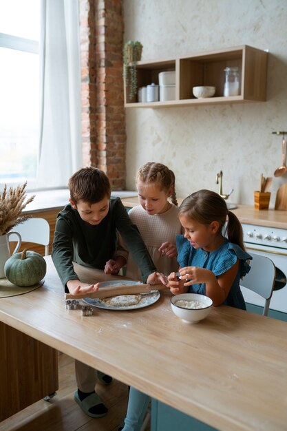 Niños de alto ángulo cocinando juntos en casa