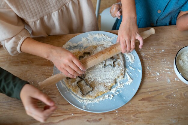 Niños de alto ángulo cocinando juntos en el interior