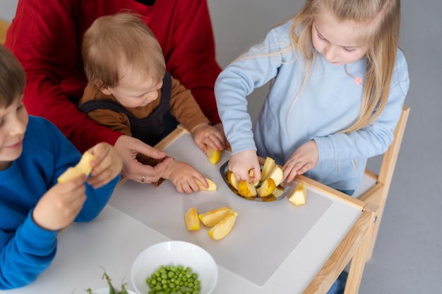 Niños de alto ángulo con comida en la mesa