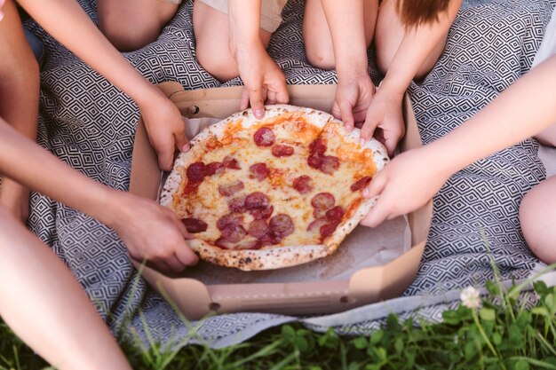 Niños de alto ángulo disfrutando de una pizza