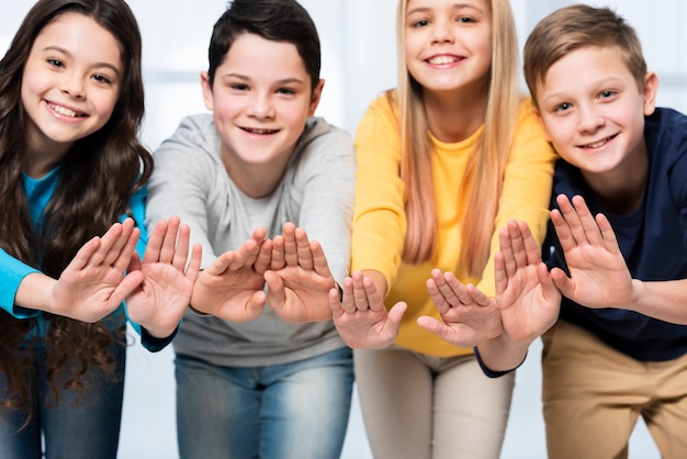 Niños de ángulo bajo mostrando las manos