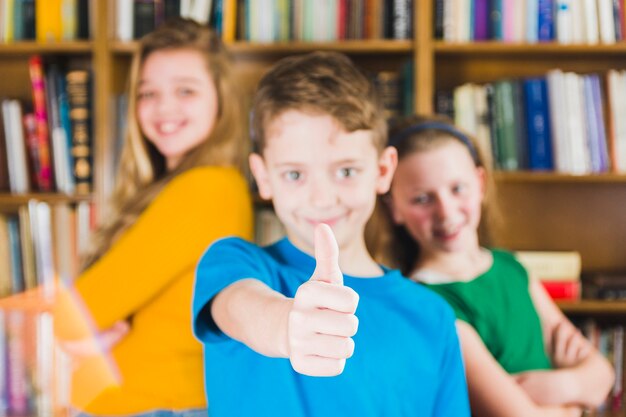 Niños animados de pie en la biblioteca