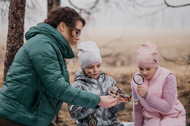 Niños aprendiendo nuevas materias científicas con su profesor al aire libre