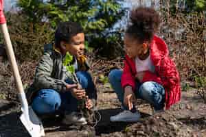 Foto gratuita niños aprendiendo a plantar un árbol.