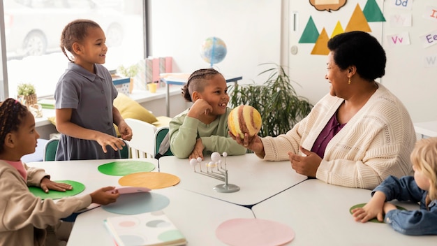 Foto gratuita niños aprendiendo sobre planetas en el aula.