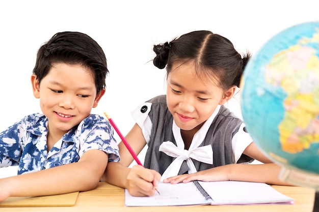 Los niños asiáticos están estudiando felizmente con el globo borroso sobre el fondo blanco