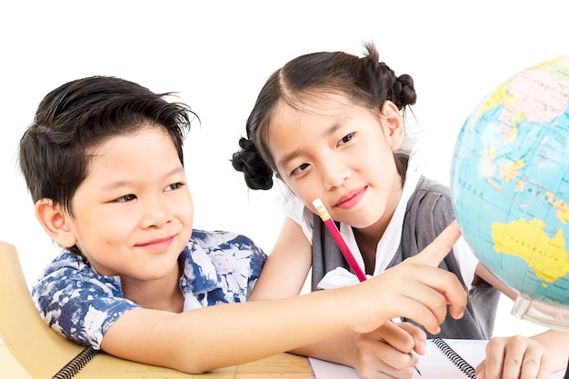 Los niños asiáticos están estudiando el globo sobre fondo blanco