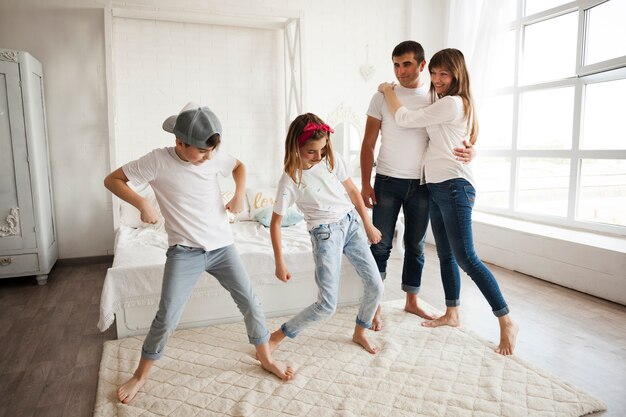 Niños bailando frente a sus padres amorosos en casa.