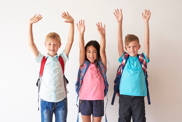 Niños en bakcground blanco con las manos arriba