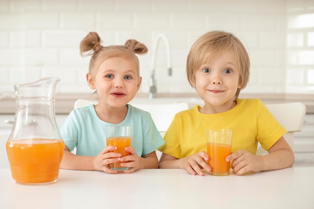 Niños bebiendo jugo en casa