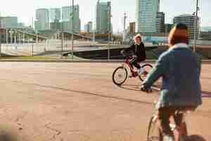 Foto gratuita niños en bicicleta al aire libre en la ciudad.