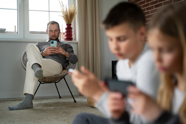 Niños borrosos de vista lateral con teléfonos inteligentes