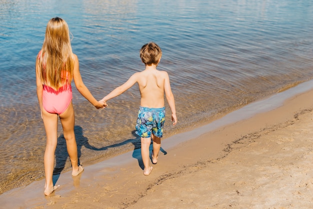 Foto gratuita niños caminando por la costa