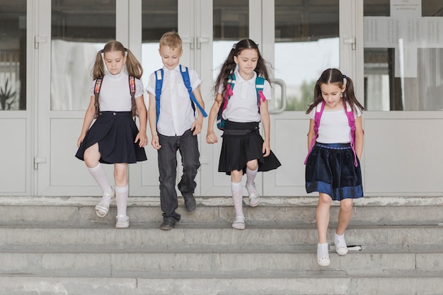 Niños caminando por las escaleras de la escuela