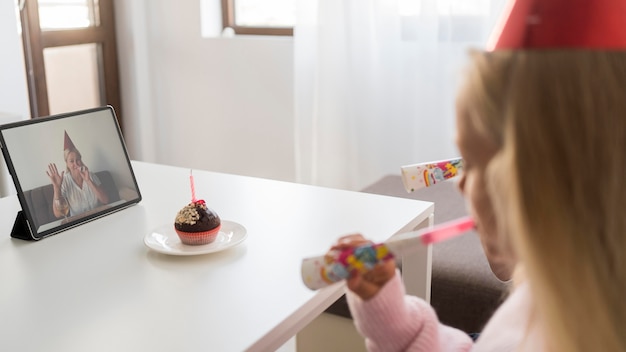 Niños en casa en cuarentena celebrando cumpleaños sobre tableta