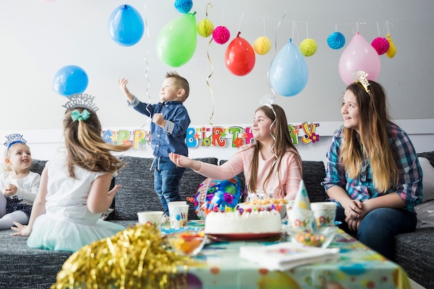 Niños celebrando cumpleaños en colorida habitación decorada