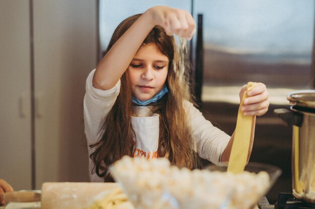 los niños cocinan pasta en una clase magistral de gastronomía