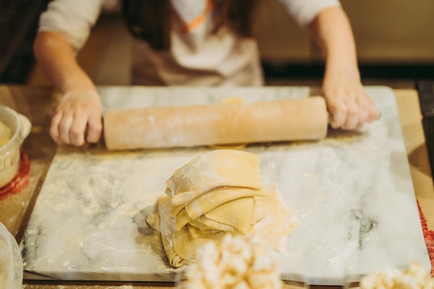 los niños cocinan pasta en una clase magistral de gastronomía