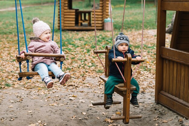 Niños en columpios en el patio de recreo