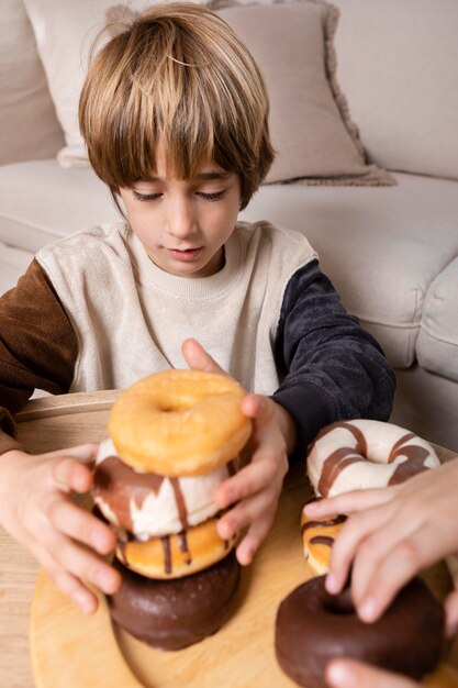 Niños comiendo donas en casa