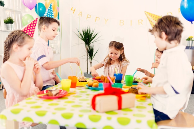 Niños comiendo dulces en la mesa