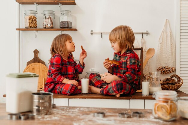 Niños comiendo galletas juntos el día de navidad