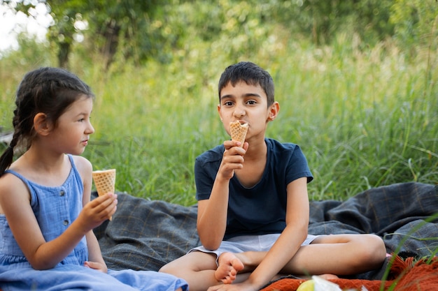 Foto gratuita niños comiendo helado juntos al aire libre