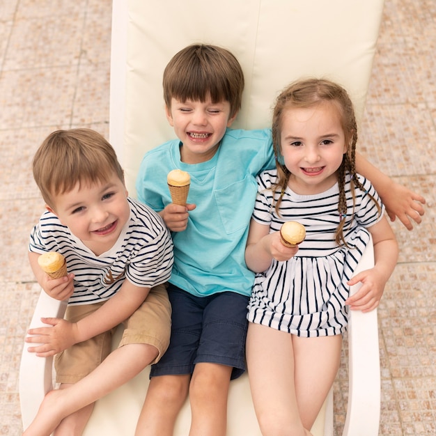 Niños comiendo helado mientras está sentado en la cama solar