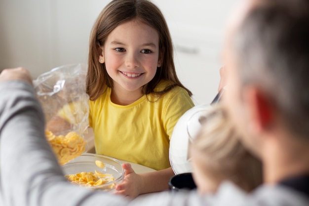 Foto gratuita niños comiendo juntos con su familia.