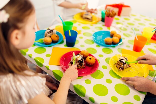 Niños comiendo pastel de chocolate en la mesa