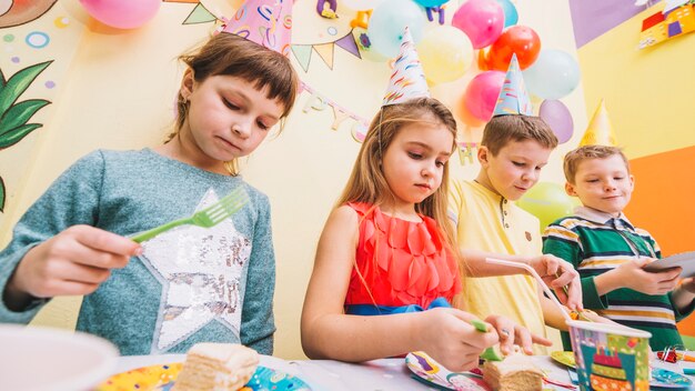 Niños comiendo pastel en la fiesta de cumpleaños