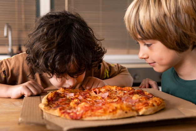 Niños comiendo pizzas juntos