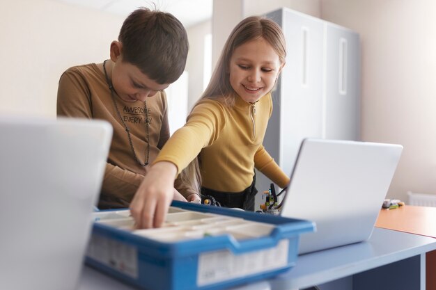 Niños construyendo un robot con componentes electrónicos