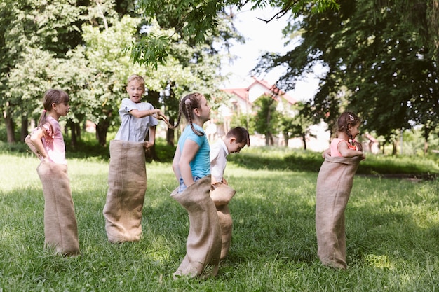 Niños corriendo en bolsas de arpillera.