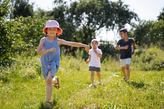 Foto gratuita niños corriendo y jugando en el campo de hierba al aire libre